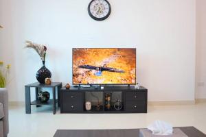 a living room with a tv on a wall at Serene 1BR Nook -Reem Island Stay in Abu Dhabi
