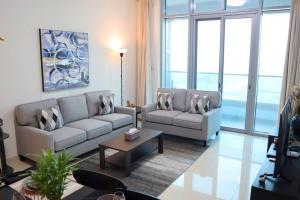 Una sala de estar con dos sofás y una mesa. en Al Reem Cozy 1BR Apartment - Comfortable Stay Near Reem Mall & Al Maryah Island, en Abu Dabi