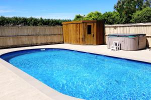 a swimming pool in a backyard with a wooden fence at Miranda Farm - Away from city, surrounded by animals in Kaiapoi