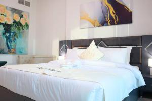 a bedroom with a large white bed with flowers on it at Al Reem Cozy 1BR Apartment - Comfortable Stay Near Reem Mall & Al Maryah Island in Abu Dhabi