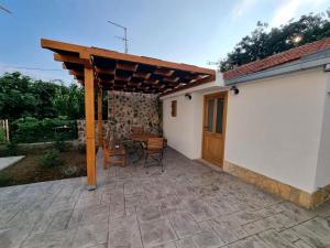 a patio with a wooden pergola and a table at Apartments by the sea Rogoznica - 22448 in Rogoznica