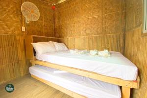 a bed in a small room with wooden walls at Glamper Grove- Real, Quezon 