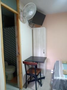 ein Zimmer mit einem Tisch, einem Bett und einem Ventilator in der Unterkunft Estancia Saraja in Ica