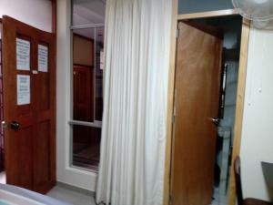 um quarto com uma porta e uma janela com uma cortina em HOTEL SARAJA em Ica