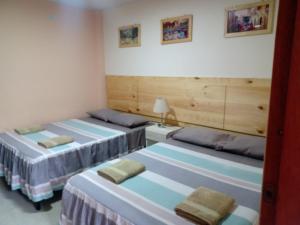 um quarto com duas camas num quarto em HOTEL SARAJA em Ica