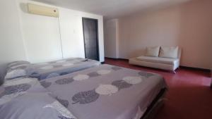 een hotelkamer met 2 bedden en een stoel bij Apartamentos Flowers House in Valledupar