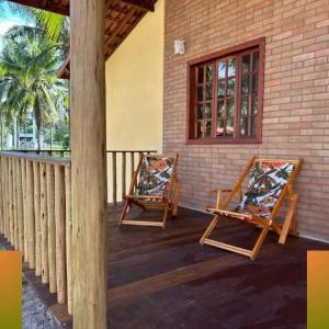 two chairs on the porch of a house at Glamping Bio-Dorf Casa 5 in Trairi