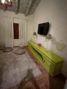 un salon avec une table verte et une télévision à écran plat dans l'établissement NuriahBoutique, à Boliqueime
