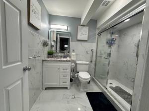 a bathroom with a shower and a toilet and a sink at Luxury 2-Bedrooms 2-Bathrooms Near NYC/EWR in Newark