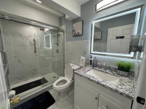 a bathroom with a shower and a toilet and a sink at Luxury 2-Bedrooms 2-Bathrooms Near NYC/EWR in Newark