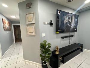 a living room with a flat screen tv on a wall at Luxury 2-Bedrooms 2-Bathrooms Near NYC/EWR in Newark