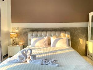 a bedroom with a bed with a stuffed animal on it at Smaids Room in Lampang
