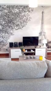 a living room with a couch and the eiffel tower at One bedroom appartement with city view terrace and wifi at Serra d' El Rei in Serra de El-Rei