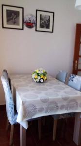 a table with a white table cloth and flowers on it at One bedroom appartement with city view terrace and wifi at Serra d' El Rei in Serra de El-Rei
