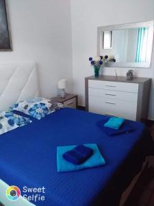 a bedroom with a blue bed with blue towels on it at One bedroom appartement with city view terrace and wifi at Serra d' El Rei in Serra de El-Rei
