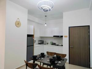 马六甲Una Cozy House Near Jonker and Heritage的一间带桌椅的厨房和一间带白色橱柜的厨房