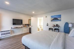 um quarto de hotel com uma cama e uma televisão de ecrã plano em Coastal Breeze Inn em Morro Bay