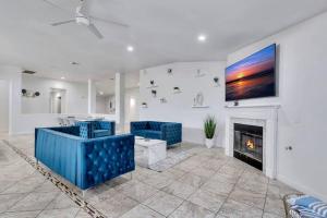 a living room with blue chairs and a fireplace at New Pool & Spa Home GameRoom FirePit Stylish in Indio