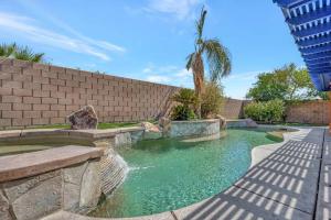 a swimming pool with a fountain in a yard at New Pool & Spa Home GameRoom FirePit Stylish in Indio