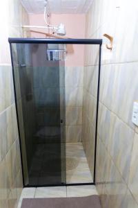 y baño con ducha y puerta de cristal. en Recanto do majo, en Petrópolis