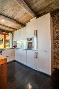 a kitchen with white cabinets and a refrigerator at Jml villa foresta in Kalawana