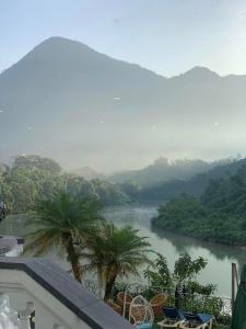 a view of a river with palm trees and mountains at Phoenix Hotel H&agrave; Giang in Ha Giang