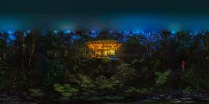 a building in the middle of a forest at night at Puyu Glamping in Tarqui