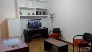 un soggiorno con TV e 2 sedie di departamento tucuman 672 a Buenos Aires