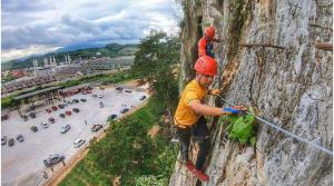 a man climbing a rock wall with a child on it at Putra 2 Homestay in Gua Musang