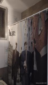 a poster of two men in suits in a bathroom at departamento tucuman 672 in Buenos Aires