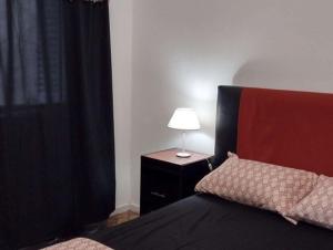 una camera con letto e lampada su comodino di departamento tucuman 672 a Buenos Aires