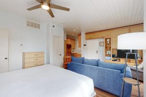 een slaapkamer met een blauwe bank en een plafondventilator bij Starfish in Padre Island