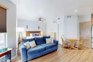 een woonkamer met een blauwe bank en een bed bij Starfish in Padre Island