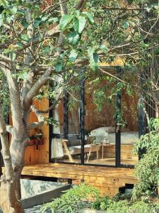 una casa en el árbol con terraza y mesa en XOM Organic Farm Stay, en Pleiku