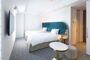 מיטה או מיטות בחדר ב-Hotel Comento Yokohama Kannai