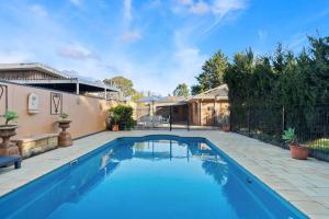 a swimming pool in a backyard with a fence at Beachside SandDunes Villa Waterslide Gas Heat Pool in Tootgarook