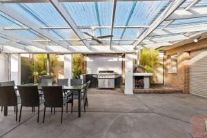 a patio with a table and chairs and a stove at Beachside SandDunes Villa Waterslide Gas Heat Pool in Tootgarook