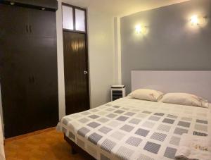 een slaapkamer met een bed en een zwarte deur bij Hotel Dorado in Moyobamba