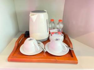 una bandeja con dos tazas de té y una licuadora en Singaraja Hotel - CHSE Certified, en Singaraja