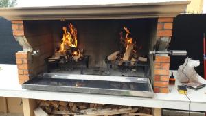 a large brick fireplace with fire in it at Zagreb4you Apartments - Family paradise with sauna in Zagreb