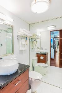 bagno con lavandino, servizi igienici e specchio di Private Condo in Hotel Arya Full Water Views includes parking a Miami