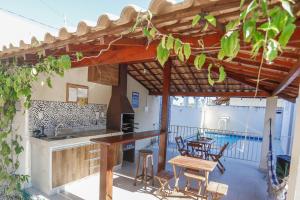 una cocina al aire libre con mesa y sillas en un patio en Apto Taperapuan 2 quartos com piscina perto praia, en Porto Seguro