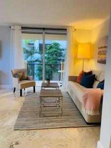 Cozy 1 bedroom unit located in a Condo Hotel in the heart of Coconut Grove Free Parking في ميامي: غرفة معيشة مع أريكة وطاولة قهوة