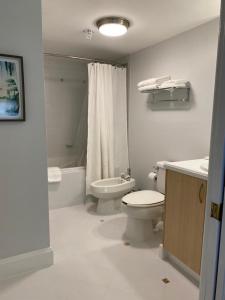 Cozy 1 bedroom unit located in a Condo Hotel in the heart of Coconut Grove Free Parking في ميامي: حمام مع مرحاض ومغسلة وحوض استحمام