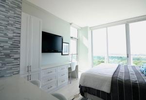 Coconut Grove 21st Floor Private Studio-Parking & WIFI included في ميامي: غرفة نوم بسرير وتلفزيون بشاشة مسطحة