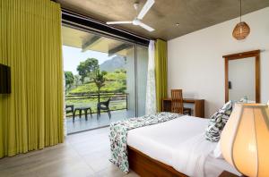 una camera da letto con un letto e una grande finestra di Tara Waterfall a Rakwana