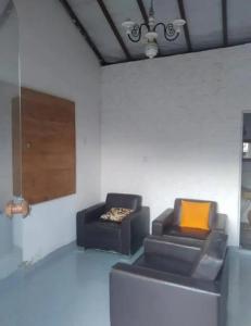 - un salon avec deux chaises et un canapé dans l'établissement Vilarejo do aconchego, à Santa Cruz de Minas