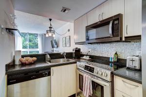 a kitchen with a sink and a stove top oven at Cute 1 bedroom unit located in Condo Hotel in the heart of Coconut Grove Free Parking in Miami