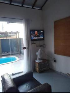 - un salon avec un canapé et une télévision murale dans l'établissement Vilarejo do aconchego, à Santa Cruz de Minas