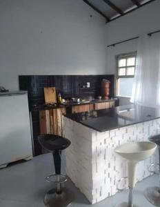 une cuisine avec un comptoir et deux tabourets dans l'établissement Vilarejo do aconchego, à Santa Cruz de Minas